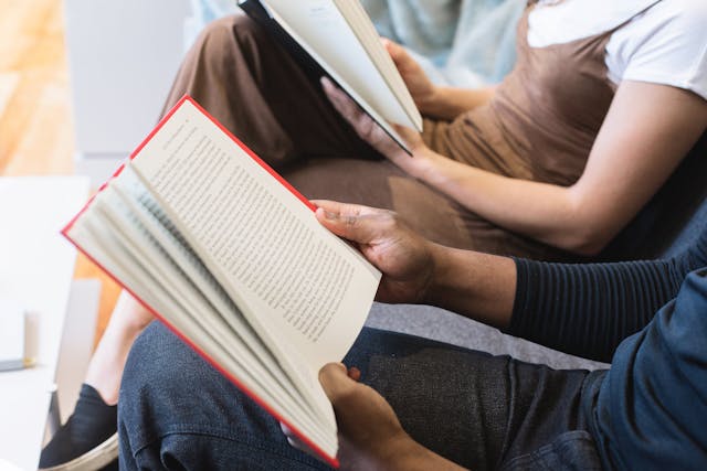Two people holding open books