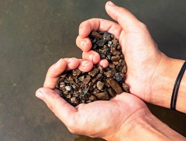 Person holding small stones in the hands, in the shape of a heart