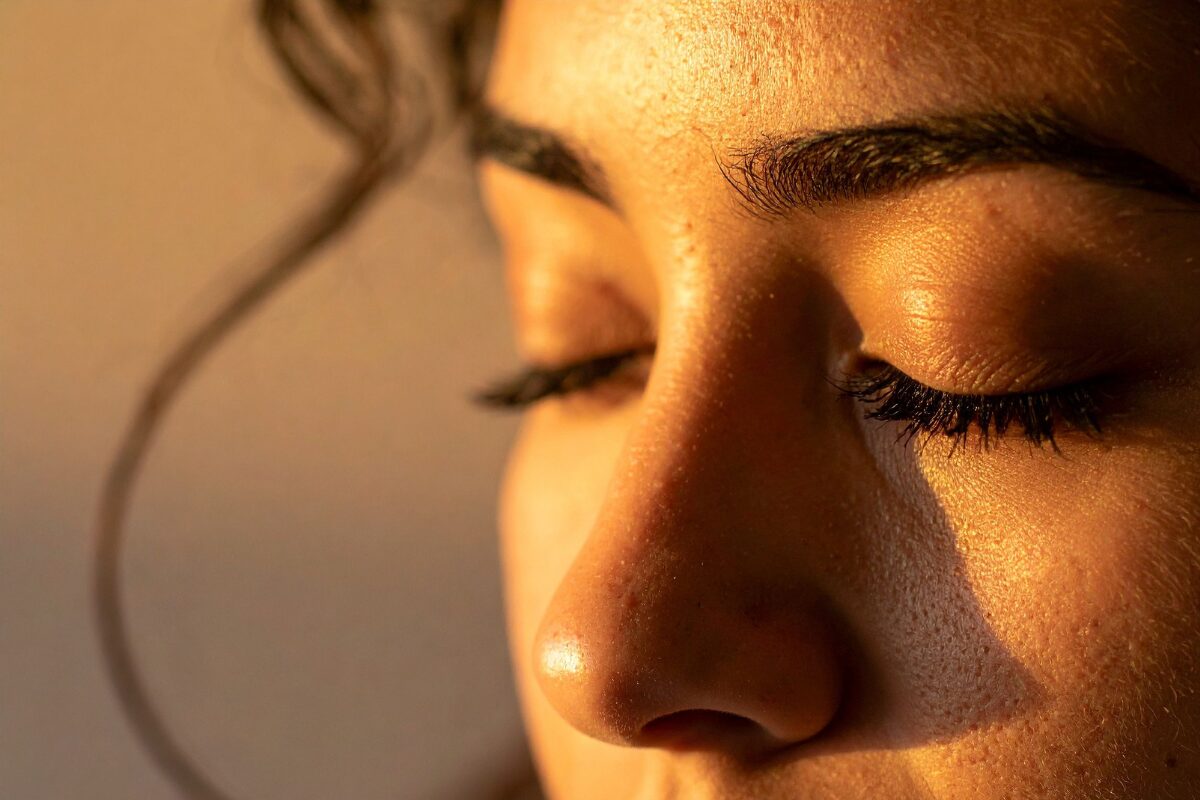 Cropped photo of a woman's face. She has her eyes closed, as though she is meditating.