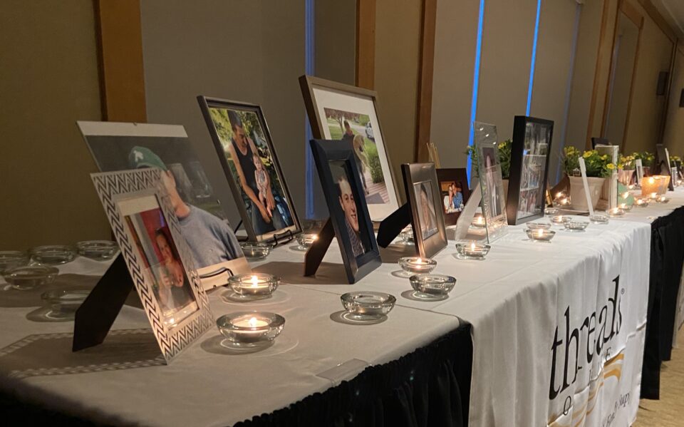 The reflections table covered in framed photos of loved ones and lit candles.